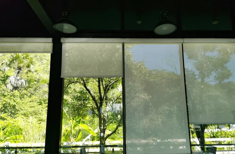Glass patio doors fitted with roller blind screens overlooking a garden