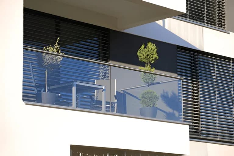 Dark exterior shutters fitted to a modern apartment balcony
