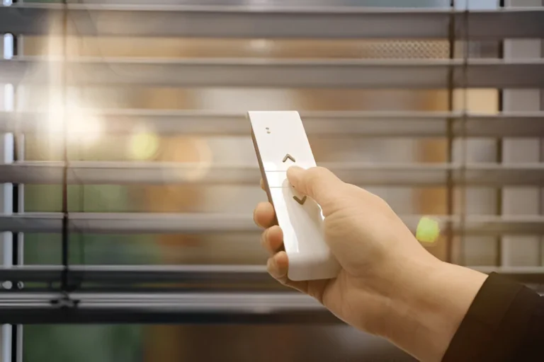 Hand operating a remote control for motorised blind screens