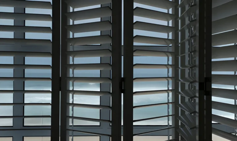 Dark tier-on-tier shutters fitted to an interior window with an ocean view