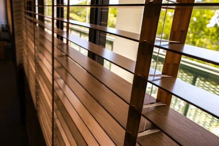 Close-up of wooden Venetian shutter slats on a balcony window